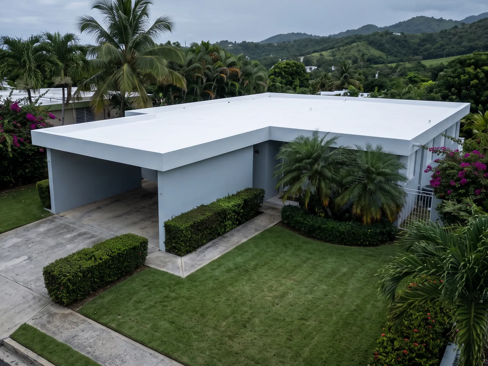 Vista aérea de una casa en Puerto Rico con el techo recién sellado en blanco, el acabado uniforme y el borde del pretil limpio.